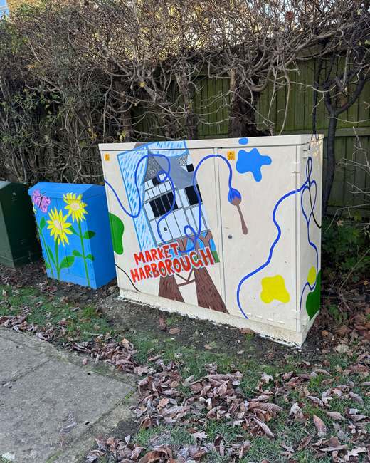 Painted utility cabinets on the Market Harborough Art Trail: sunflowers on one, a timber-framed building and ‘Market Harborough’ lettering on the other