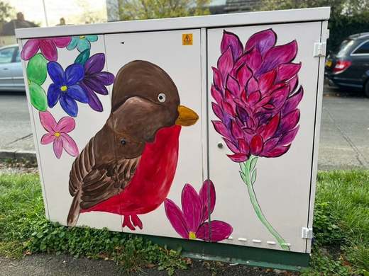 Utility cabinet painted with a robin and a tall magenta flower on Walcot Road